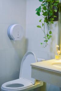 a bathroom with a toilet and a sink and a plant at Lan House Youth Apartment in Guangzhou