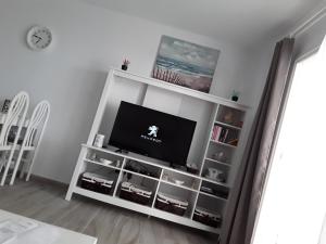a white book shelf with a flat screen tv at Le farniente in Costa Teguise