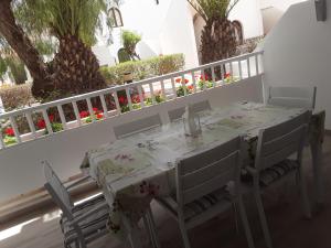 a white table and chairs on a balcony with flowers at Le farniente in Costa Teguise