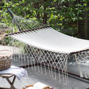 a hammock on a patio with a row of chairs at Cancun Blue Airport in Cancún