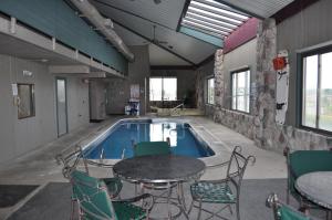 una piscina con mesas y sillas en un edificio en Super 8 by Wyndham Petoskey, en Petoskey