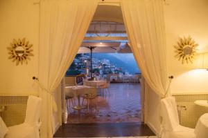a room with a door open to a dining room with a view at Hotel Posa Posa in Positano