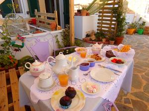 a table with food and cups and plates of food at Locadiera Pansion in Ermoupoli