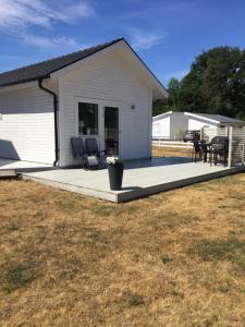 a house with a porch with chairs and a patio at Köpingsvik Holiday Home in Köpingsvik