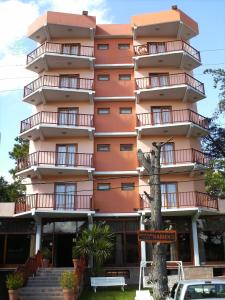 a tall orange building with a sign in front of it at Hosteria Kaiken II in Villa Gesell