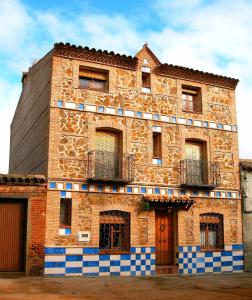 un antiguo edificio de ladrillo con ventanas y balcones. en Casa rural El Pinche, en Espinoso del Rey