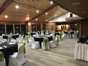 a banquet hall with white tables and green bows at Round Barn Lodge in Spring Green