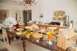a kitchen with a table filled with lots of food at CHA Royal Plaza Hotel in Apucarana