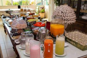 a buffet with many different types of drinks on a counter at CHA Royal Plaza Hotel in Apucarana