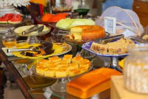 a buffet filled with different types of cakes and pies at CHA Royal Plaza Hotel in Apucarana