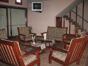a living room with chairs and a table and a tv at Hosteria Kaiken II in Villa Gesell