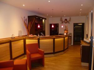 a bar in a restaurant with a counter and chairs at Hotel Grüner Jäger in Travemünde