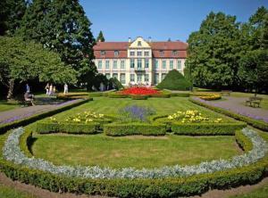a garden with flowers in front of a large building at Apartament w Oliwie in Gdańsk