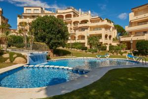 una piscina frente a un gran edificio en Residence Velas Garden Pool Suite, en S'Agaró