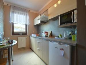 W kuchni znajduje się biała lodówka i kuchenka mikrofalowa. w obiekcie Apartament na Jagiellońskiej w Kołobrzegu