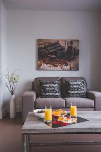 a living room with a couch and a table with orange juice at Les suites de la chocolaterie in Ville-Marie
