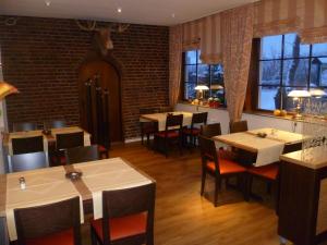 a restaurant with tables and chairs in a room at Hotel Grüner Jäger in Travemünde