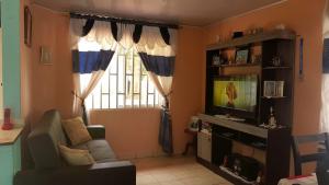 uma sala de estar com um sofá e uma televisão em Posada Sorybego em San Andrés