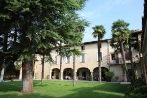 ein großes Gebäude mit Palmen im Hof in der Unterkunft L'Unicorno Agriturismo in bedizzole