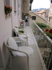 une rangée de chaises assises sur un balcon dans l'établissement Apartman Milena, à Korčula