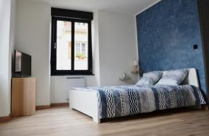 1 dormitorio con 1 cama con pared azul en Le cyclade, appartement de standing en hyper-centre., en Sarreguemines