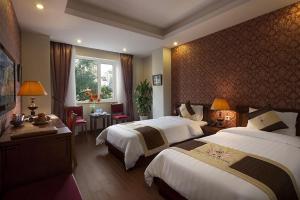 سرير أو أسرّة في غرفة في First Eden Hotel - Hang Bun