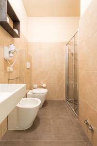 a bathroom with a toilet and a sink and a shower at Hotel Helvetia in Lido di Jesolo