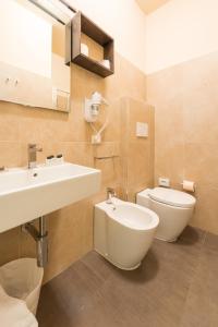 a bathroom with a sink and a toilet at Hotel Helvetia in Lido di Jesolo