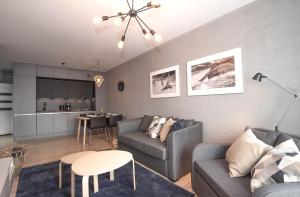 a living room with a couch and a table at LATO apartament Polanki Park z miejscem parkingowym in Kołobrzeg