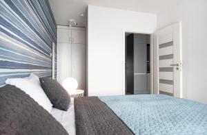 a bedroom with a large bed with a blue and white headboard at LATO apartament Polanki Park z miejscem parkingowym in Kołobrzeg +18 photos