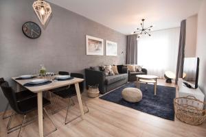 a living room with a table and a couch at LATO apartament Polanki Park z miejscem parkingowym in Kołobrzeg