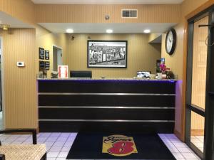 a bar in a restaurant with a clock on the wall at Super 8 by Wyndham Franklin Hwy 31 in Franklin