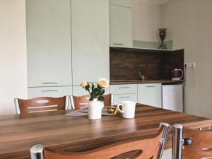 a kitchen with a wooden table with flowers on it at Azzurro Apartment - ideal for your seaside escape in Burgas in Burgas
