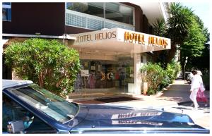 a store with a car parked in front of it at Hôtel Hélios in Juan-les-Pins