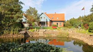 a large house with a pond in front of it at Provincija in Palanga