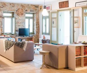 a living room with two couches and a tv at Plori House in Skiros