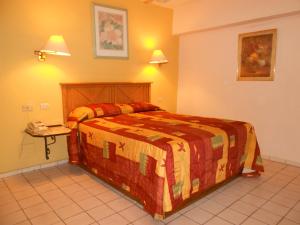 1 dormitorio con 1 cama grande en una habitación en Hotel Suites Kino, en Hermosillo