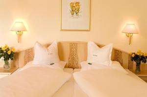 two beds with white pillows in a hotel room at Hotel Alpen Residence in Ehrwald