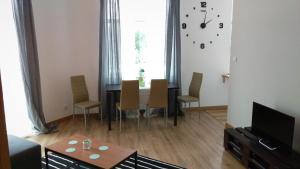 sala de estar con mesa, sillas y reloj en Młyńska2 en Bielsko-Biala