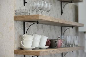 a wooden shelf with cups and glasses on it at Ana's Apartment in Old Tbilisi in Tbilisi City