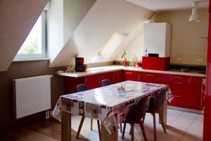 une cuisine avec des placards rouges et une table avec des chaises dans l'établissement Home-sweet-home, à Haguenau