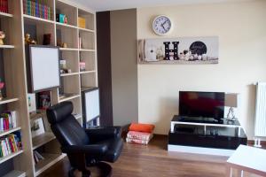 un salon avec une chaise et une télévision dans l'établissement Home-sweet-home, à Haguenau