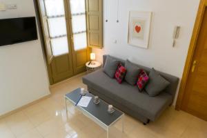 sala de estar con sofá y mesa en MALAMA Apartamentos Turísticos, en Málaga