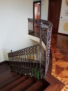 a staircase with a metal railing and a mirror at B&B Villa Francesca in Soverato Marina