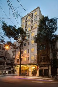 ein hohes Gebäude in der Nacht auf einer Stadtstraße in der Unterkunft First Eden Hotel - Hang Bun in Hanoi