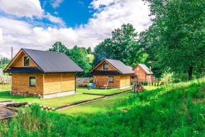 een paar kleine houten huizen in een veld bij Domki na Łazach in Uherce Mineralne