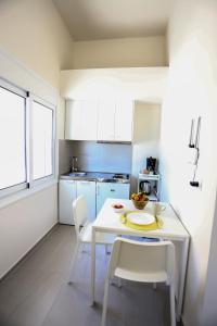 a small kitchen with a white table and chairs at Skouros Villa in Kastrí +34 photos