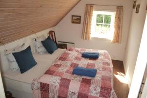 a bedroom with a bed with two blue pillows on it at Tvillinggaard Thy in Vang
