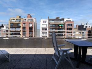a table and chairs on a roof with buildings at Dakstudio Met Reuze Zonneterras in Middelkerke