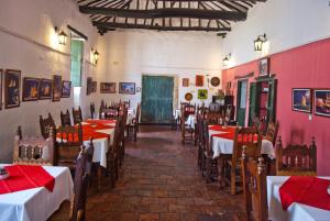 a restaurant with tables and chairs with red tablecloths at Hotel Mision Santa Barbara in Barichara